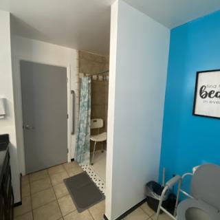 A bright and modern bathroom space featuring a shower area and a vibrant blue accent wall.