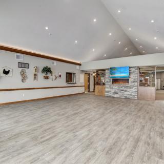 A modern reception area with wood flooring, decorative walls, and ceiling lights.