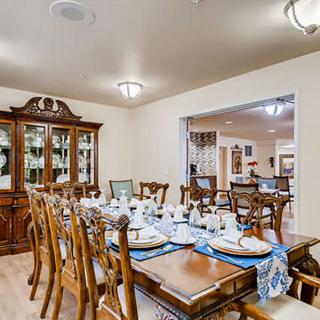 A well-decorated dining room with an elegant table set for a meal, featuring wooden chairs and a china cabinet.