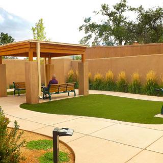 A serene outdoor garden with a gazebo and benches along a winding pathway.