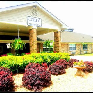 A welcoming entrance to a hotel surrounded by vibrant landscaping.
