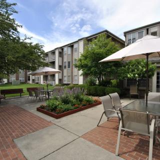 A serene courtyard in an apartment complex with outdoor seating and garden areas.