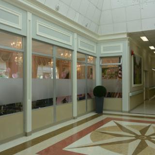 A spacious lobby with elegant architectural details and glass partitions.