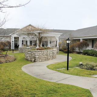 A scenic view of a landscaped area with a pathway leading to a large building.