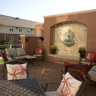 A cozy outdoor patio area with comfortable seating and a decorative fountain.