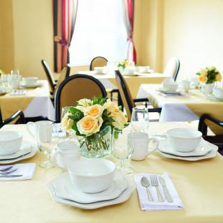 An elegantly set dining table with floral centerpiece in a restaurant setting.