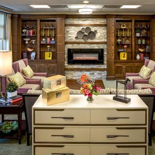 A cozy living room with a fireplace, bookshelves, and comfortable seating.