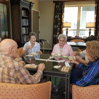 A group of elderly people enjoying a meal together in a cozy setting.