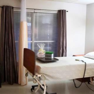A hospital room with a bed and medical equipment.