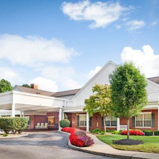 A welcoming building with a landscaped driveway and a backdrop of a clear blue sky.