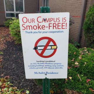 A sign indicating that the campus is smoke-free, discouraging smoking on the premises for health reasons.