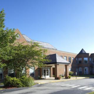 A brick building with trees and a clear blue sky.