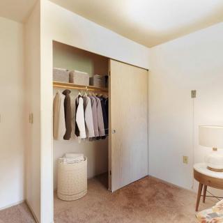 A minimalist bedroom closet with clothes neatly organized.