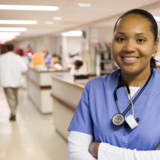 A confident nurse smiling in a hospital setting.
