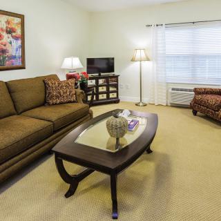 A cozy living room with a sofa, coffee table, and television.