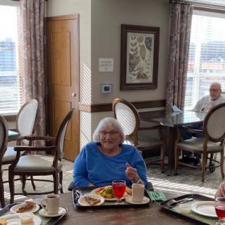 Elderly individuals enjoying a meal together in a communal dining area.