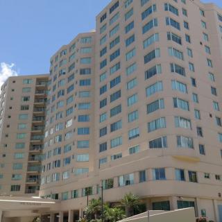 A high-rise building with numerous windows under a clear blue sky.