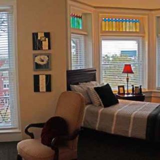 Cozy bedroom with large windows and stained glass accents.