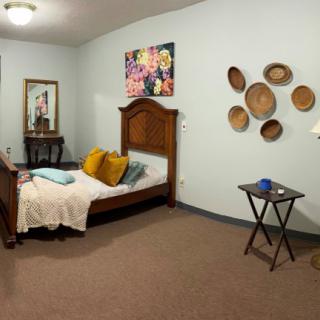 Cozy bedroom with decorative wall art and wooden furniture.