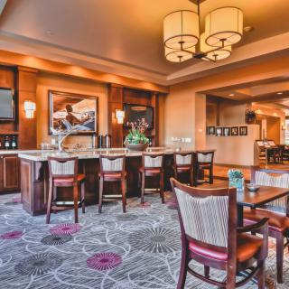 A cozy restaurant interior with a bar and seating area, featuring elegant decor and warm lighting.