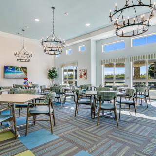 A modern dining area with elegant chandeliers and large windows providing ample natural light.