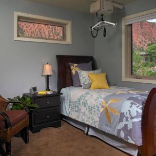 A cozy bedroom with a single bed, nightstand, and decorative elements.