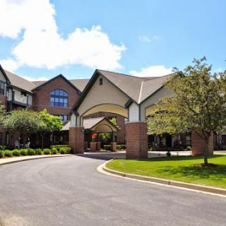 A modern building entrance with a circular driveway on a sunny day.
