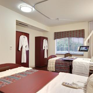 A well-furnished hotel room featuring two beds, stylish decor, and comfortable amenities.