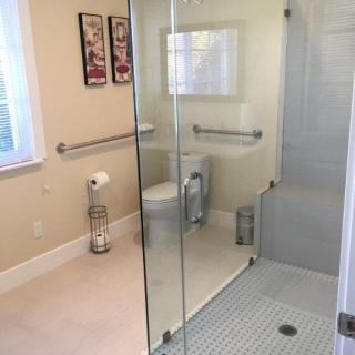 A modern bathroom featuring a glass-enclosed shower and accessible features.