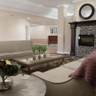 A cozy living room with modern furniture and a stone fireplace.