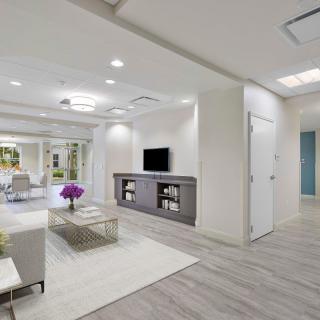 A modern, minimalist living room interior with a sofa, television, and coffee table.