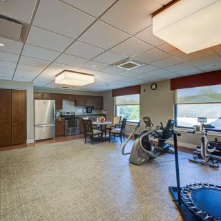 A multifunctional indoor space combining a kitchen area and exercise equipment.