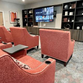 Cozy home theater setup with red chairs and a large screen TV.
