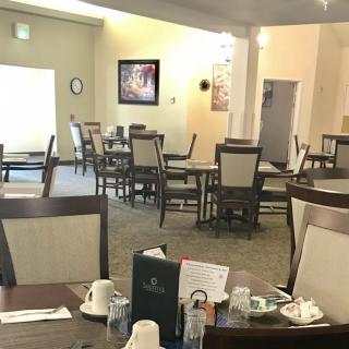 An empty dining area in a restaurant with neatly arranged tables and chairs.