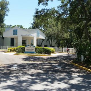Entrance to a facility surrounded by trees.