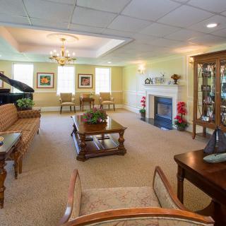 A spacious living room with elegant furnishings and a grand piano.
