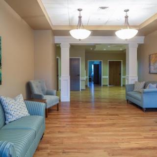 A beautifully designed lobby featuring teal sofas, wooden flooring, and modern lighting fixtures.