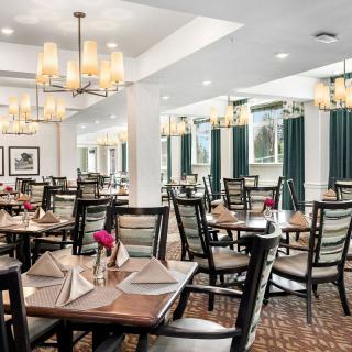 An elegantly designed restaurant dining area with neatly arranged tables and chandeliers.