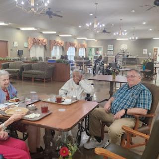 Residents enjoying their meal and each other's company in a communal dining setting.