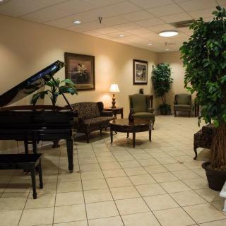 A well-decorated lobby featuring a grand piano and comfortable seating.