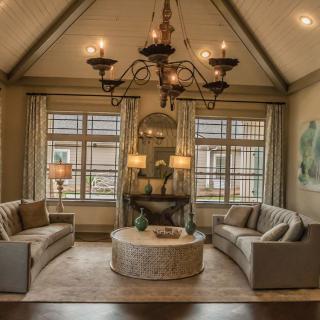 Cozy living room with elegant decor and a large chandelier.