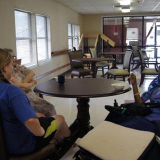 Elderly residents socializing in a nursing home common area.