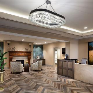 A modern lobby with elegant furnishings and a large chandelier.