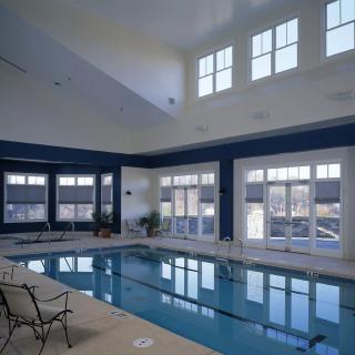A spacious indoor swimming pool area with large windows and seating.