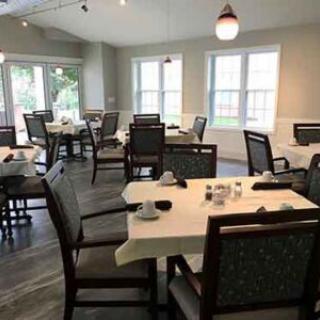 An empty dining room with neatly arranged tables and chairs.