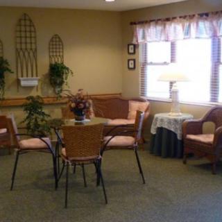 A cozy living room with wicker furniture and indoor plants.