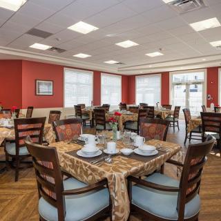 A neatly arranged dining room with tables set for a meal.