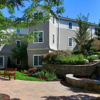 A well-maintained garden with a landscaped walkway in front of a modern building.