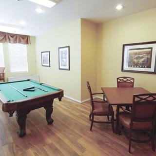 A cozy recreation room featuring a pool table and seating area with framed artwork on the walls.