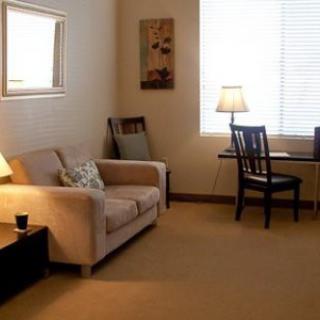 A cozy living room with a sofa, table, chairs, and soft lighting.